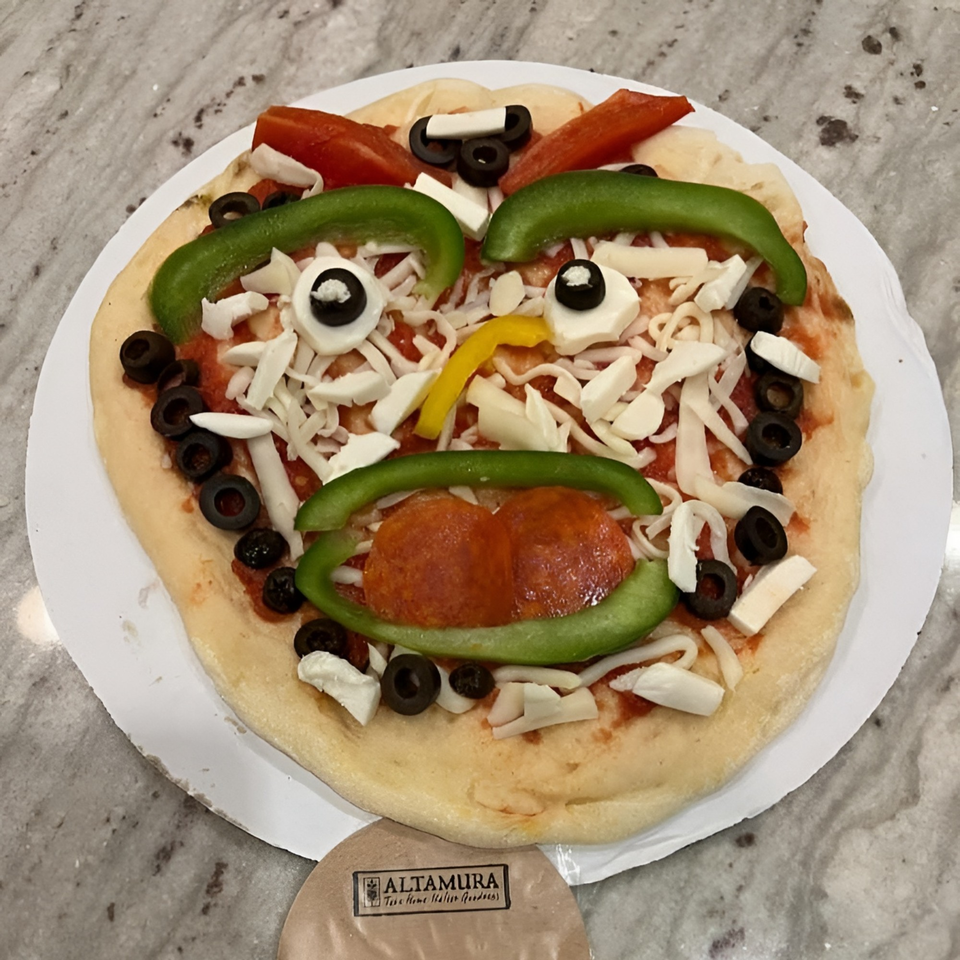 Uncooked Altamura pizza with toppings arranged to look like a face, featuring pepperoni, peppers, and olives.