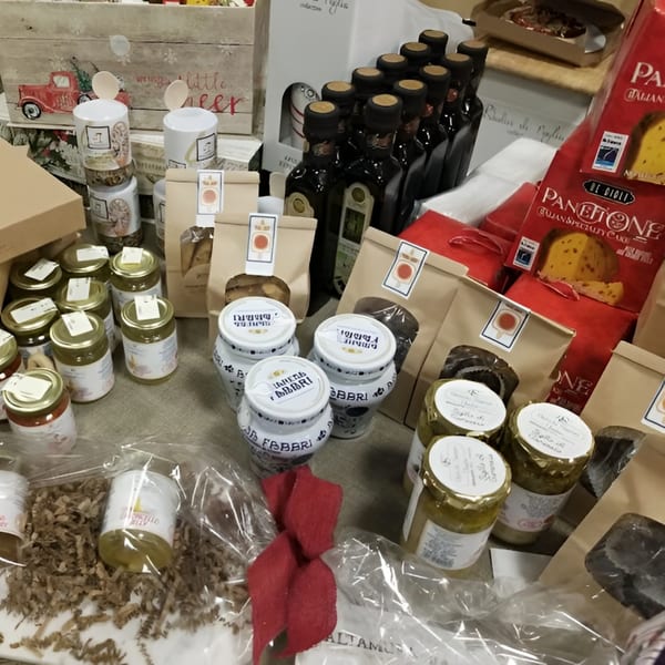 A variety of Altamura Pizza Italian products, including olive oil, panettone, jars of sauces, and gift bags.