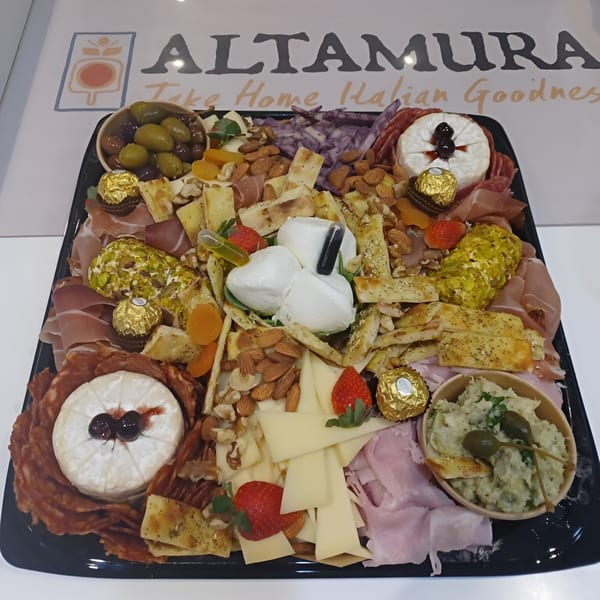A large Altamura Pizza charcuterie board with cheeses, meats, nuts, olives, and fruit.